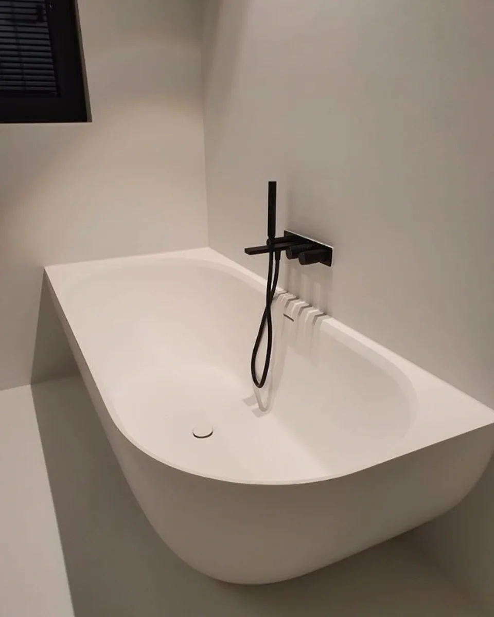 Vrijstaand bad en toilet in betonlook